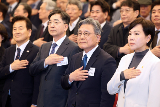 지난 4월16일 서울 여의도 국회도서관 대강당에서 이재명 더불어민주당 전 대표의 6·3 대선 싱크탱크로 알려진 '성장과 통합' 출범식이 열린 가운데 유종일·허민 상임 공동대표가 국기에 경례하고 있다. 앞줄 왼쪽부터 정동영 민주당 의원, 유종일·허민 상임 공동대표, 전현희 민주당 의원.<연합뉴스 사진>